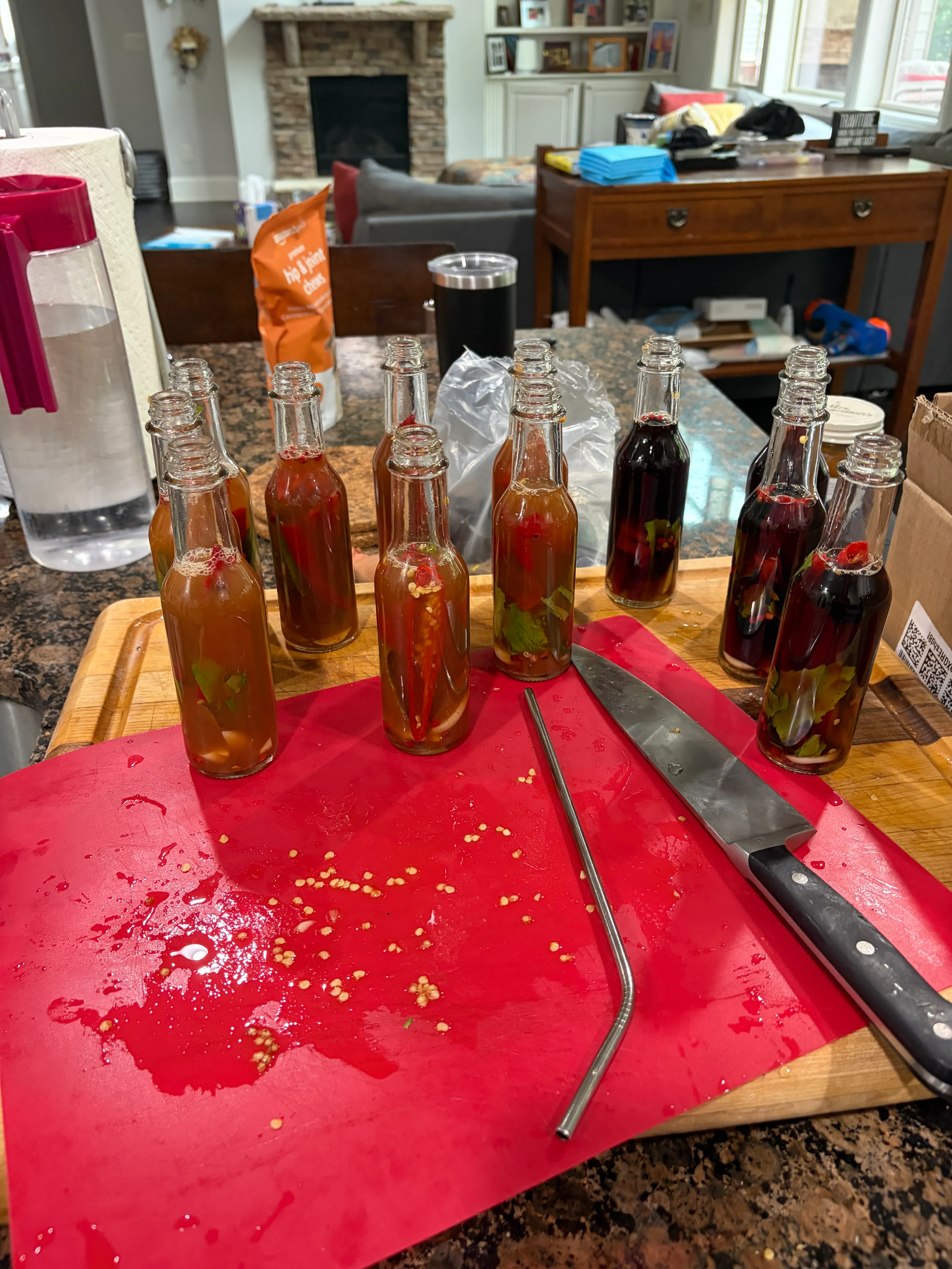 Bottles filled with vinegar — some pale amber from the raw cider vinegar, some deep red from the aged Sherry